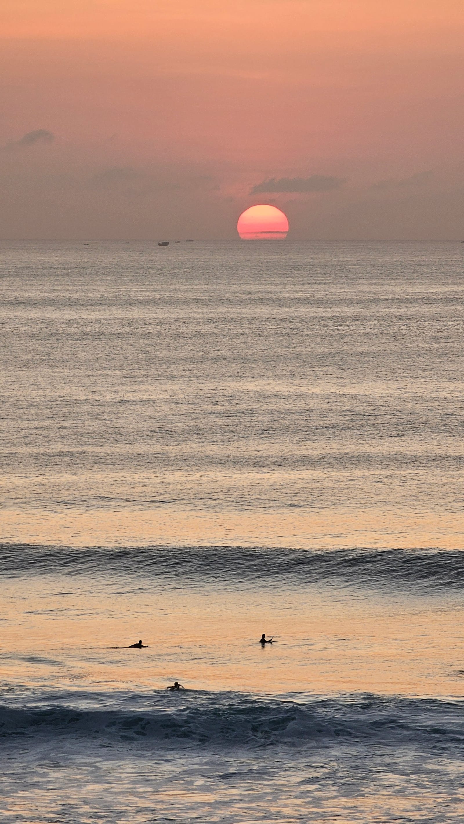 落海的夕陽與衝浪的人們